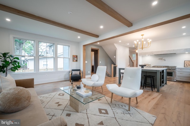 living room with an inviting chandelier, beamed ceiling, and light hardwood / wood-style flooring