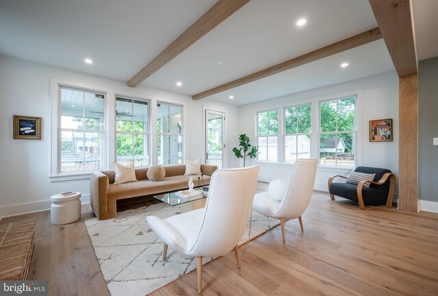 living room featuring beamed ceiling and light hardwood / wood-style flooring