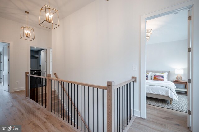 hallway featuring light wood-type flooring and a chandelier