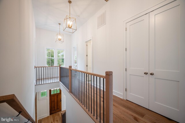 hallway featuring light wood-type flooring and a chandelier