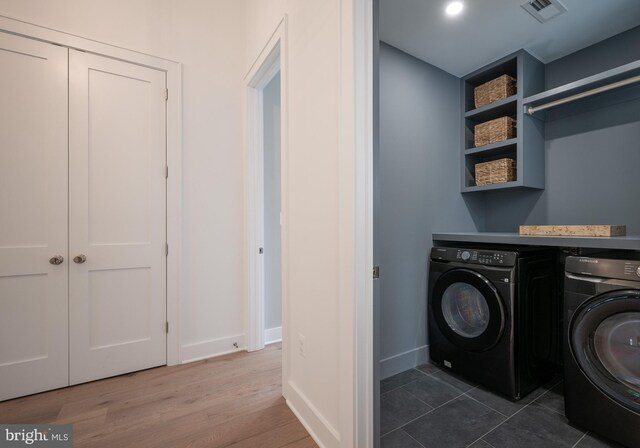 clothes washing area with independent washer and dryer and dark hardwood / wood-style flooring