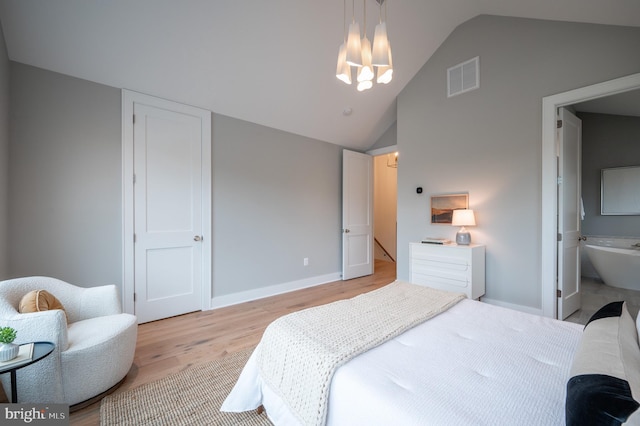 bedroom with light hardwood / wood-style flooring, connected bathroom, and vaulted ceiling