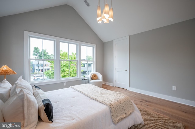 bedroom with lofted ceiling and light hardwood / wood-style flooring