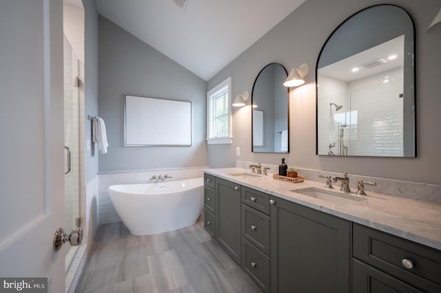 bathroom featuring vaulted ceiling, separate shower and tub, and vanity