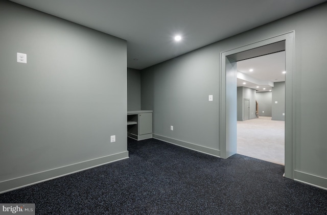 unfurnished room featuring dark carpet