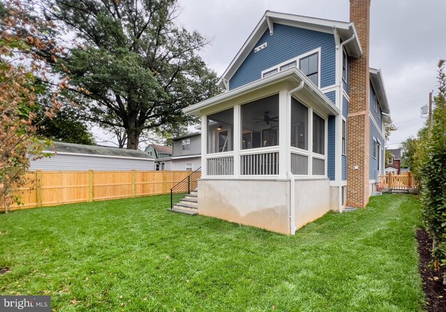 rear view of house with a lawn and a sunroom