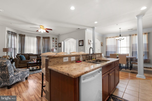 kitchen with dishwasher, light wood-type flooring, sink, and ornate columns