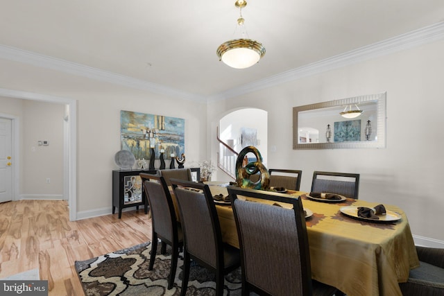 dining space with light wood-type flooring and ornamental molding