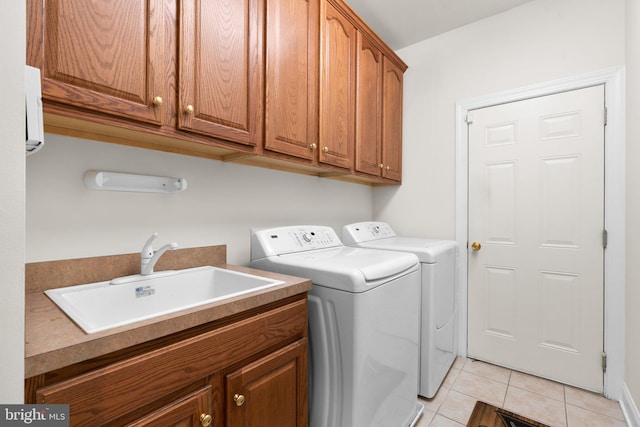 laundry room featuring cabinets, light tile patterned floors, separate washer and dryer, and sink