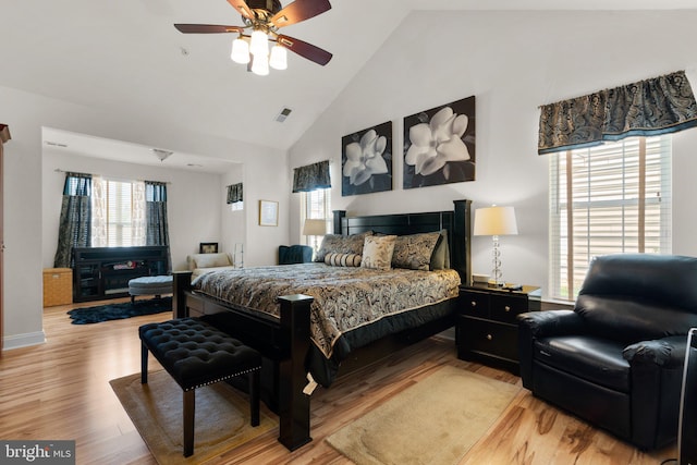 bedroom with ceiling fan, light hardwood / wood-style floors, and high vaulted ceiling