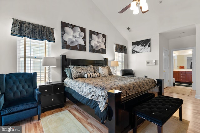 bedroom with high vaulted ceiling, light wood-type flooring, connected bathroom, and ceiling fan