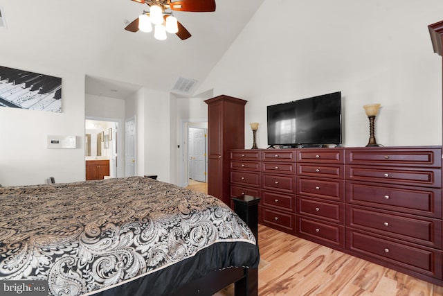 bedroom featuring light hardwood / wood-style flooring, high vaulted ceiling, ceiling fan, and ensuite bathroom