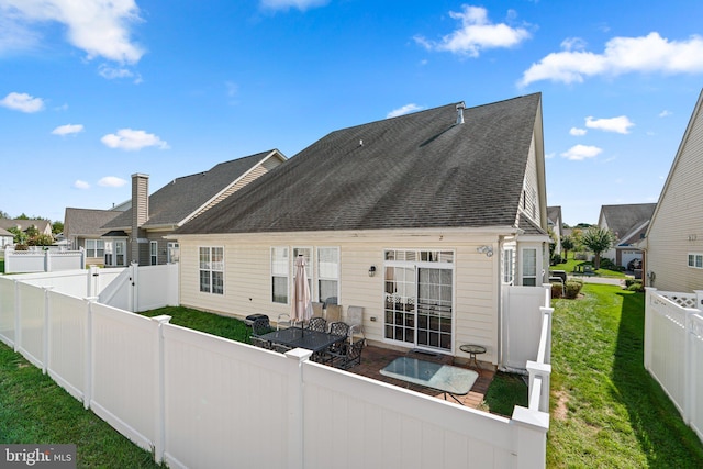 rear view of house featuring a lawn