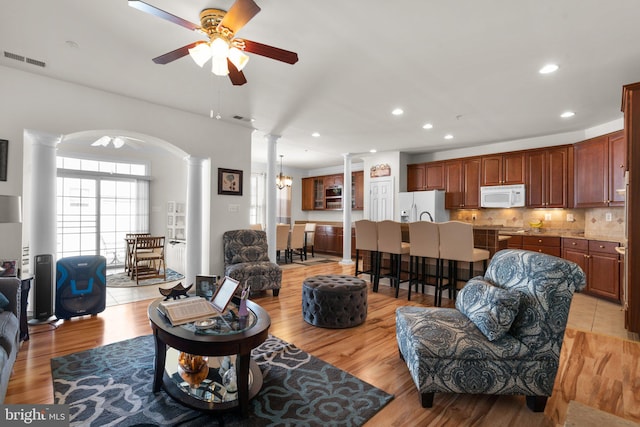 living room featuring light hardwood / wood-style floors, decorative columns, and ceiling fan