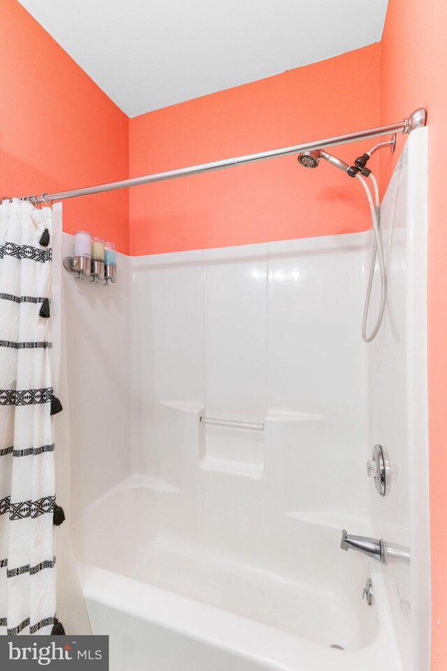 bathroom with shower / bath combo with shower curtain