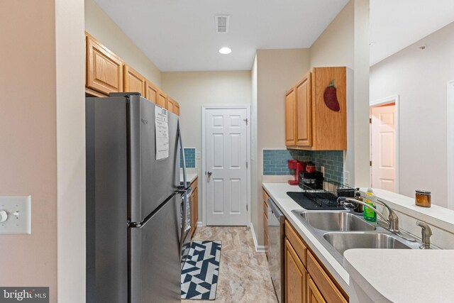 kitchen with stainless steel appliances, sink, and backsplash