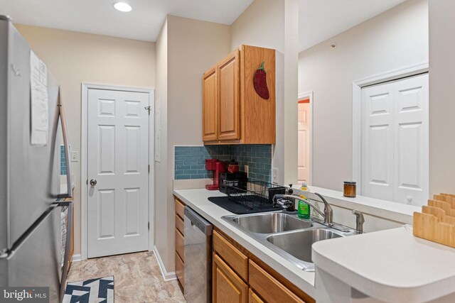 kitchen with sink, appliances with stainless steel finishes, and tasteful backsplash