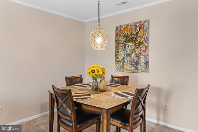 carpeted dining room featuring crown molding