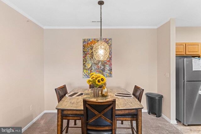 carpeted dining room featuring crown molding