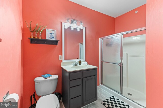 bathroom with vanity, toilet, and a shower with door