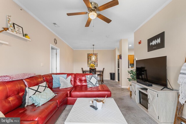 living room featuring ceiling fan, light carpet, and ornamental molding