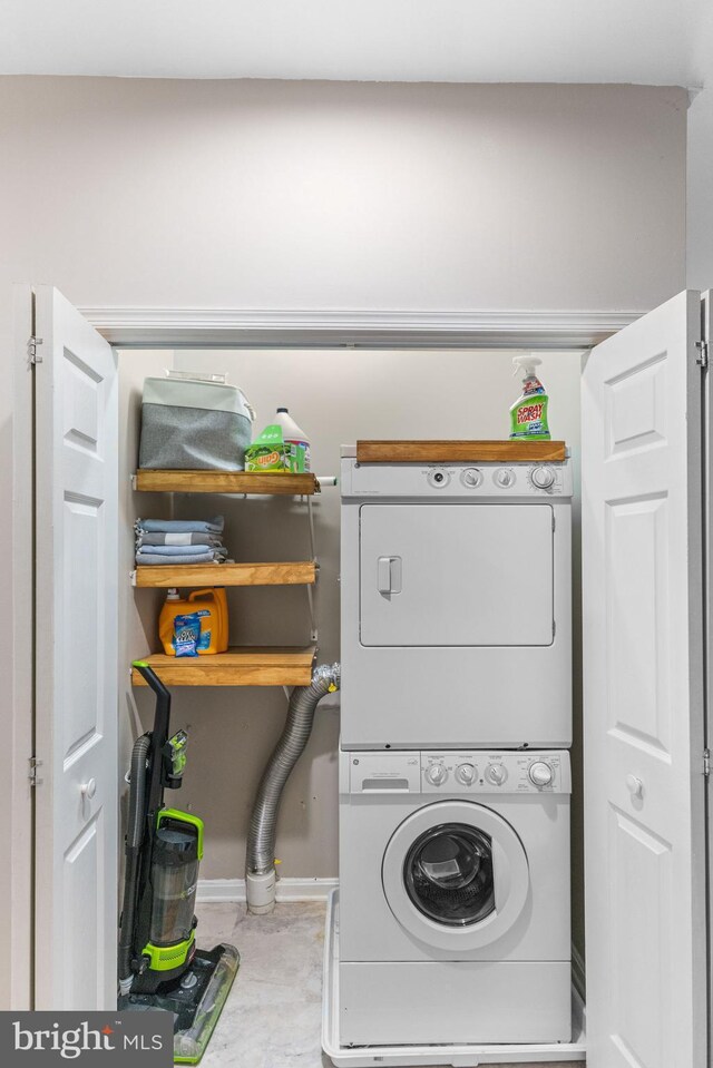 clothes washing area featuring stacked washer and dryer