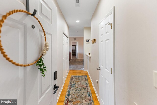 hallway with light hardwood / wood-style floors