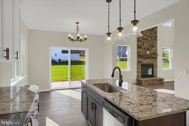 kitchen with an island with sink, light stone countertops, stainless steel appliances, and plenty of natural light