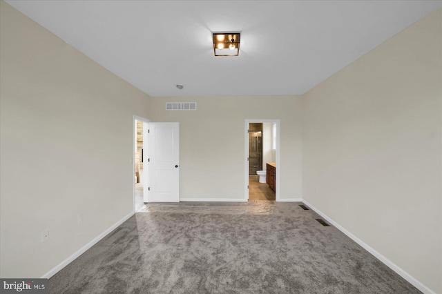 unfurnished bedroom featuring ensuite bath and carpet