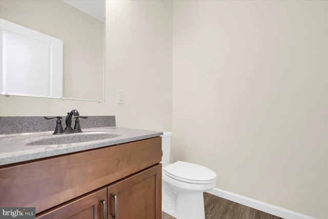 bathroom featuring hardwood / wood-style floors, vanity, and toilet