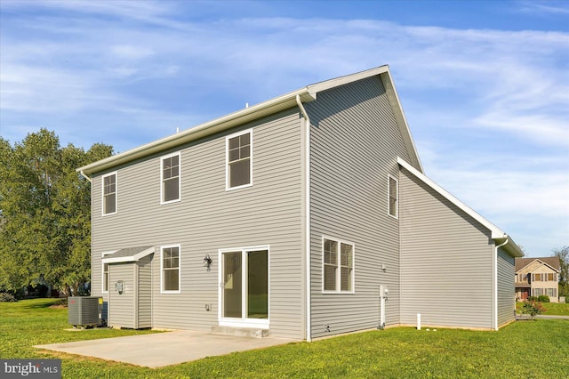 rear view of house featuring central air condition unit, a lawn, and a patio