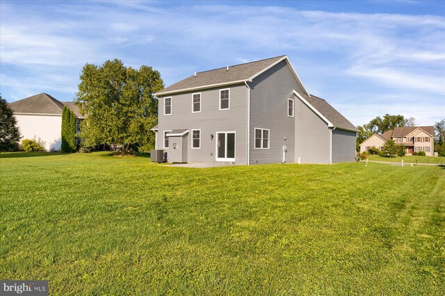 rear view of house with a lawn, a patio, and central AC unit