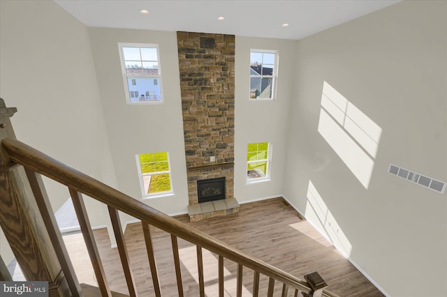 stairway featuring a fireplace, a wealth of natural light, and hardwood / wood-style flooring