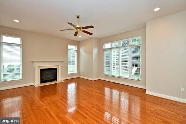 unfurnished living room with ceiling fan, light hardwood / wood-style floors, and plenty of natural light