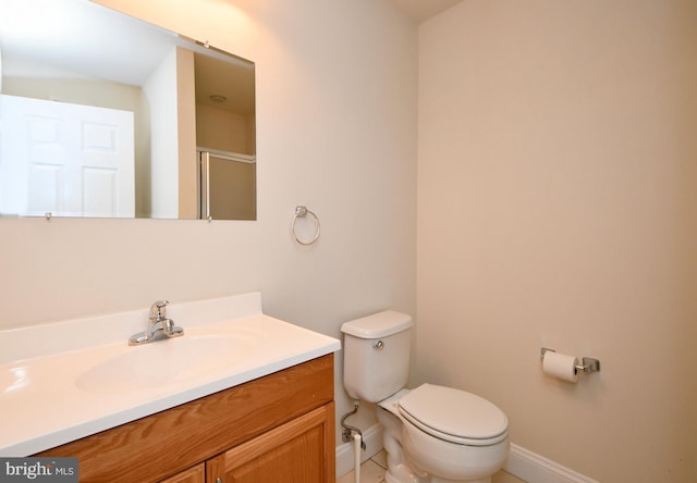 bathroom featuring vanity, toilet, and walk in shower