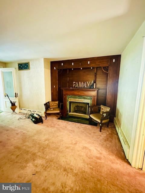 living area with a baseboard heating unit and carpet floors