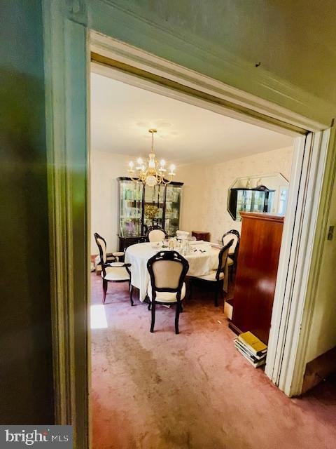 dining space with a notable chandelier and carpet floors