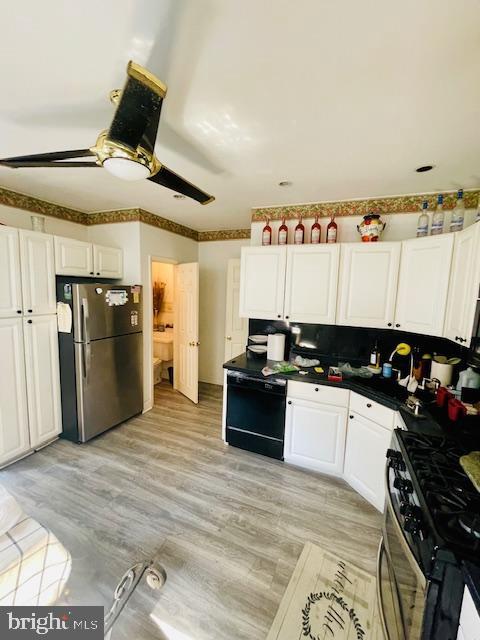 kitchen with black appliances, ceiling fan, light hardwood / wood-style flooring, and white cabinets