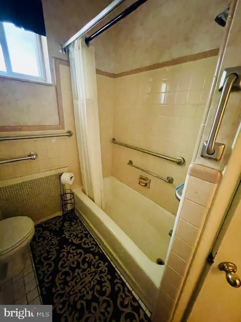 bathroom with tile walls, toilet, tile patterned flooring, and  shower combination