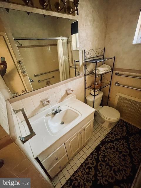 bathroom featuring a shower with shower curtain, tile patterned flooring, toilet, and vanity