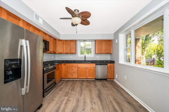 kitchen with appliances with stainless steel finishes, sink, ceiling fan, and hardwood / wood-style flooring