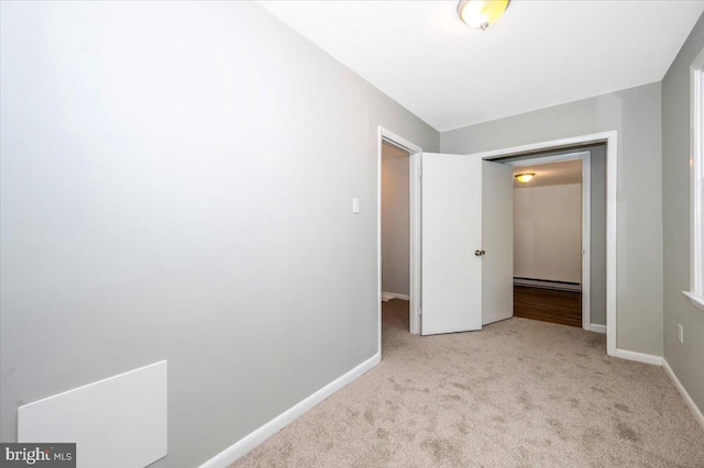 unfurnished bedroom with light carpet and a baseboard radiator