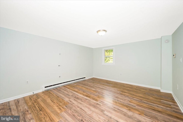 unfurnished room featuring light hardwood / wood-style floors and a baseboard heating unit