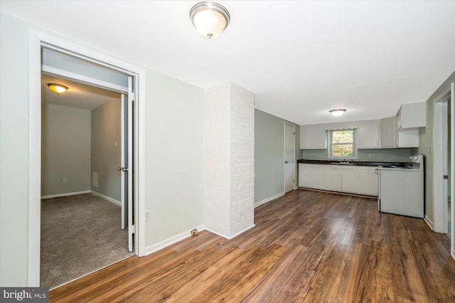 kitchen with white cabinets, sink, white range, and dark hardwood / wood-style flooring