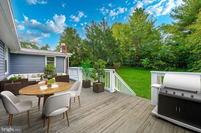 wooden deck featuring a lawn, a grill, and an outdoor hangout area