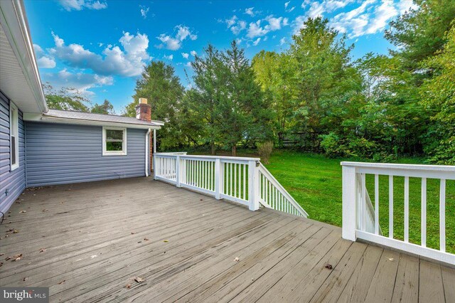 wooden terrace with a lawn