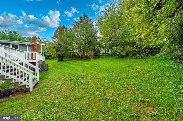 view of yard featuring central AC and a deck