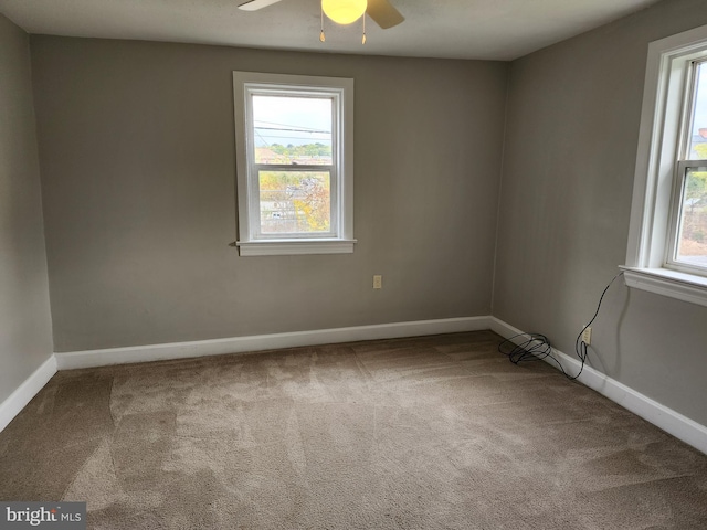 spare room with plenty of natural light, ceiling fan, and carpet flooring