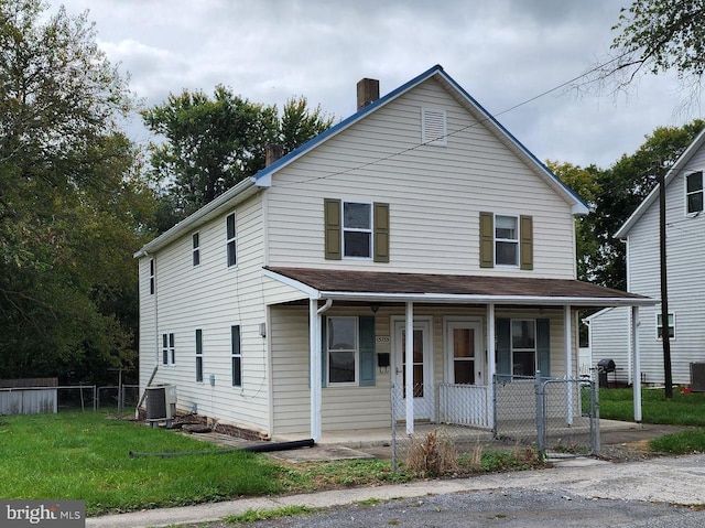 view of front of home featuring a porch, central AC unit, and a front yard