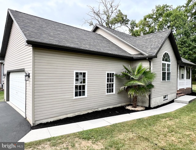 view of property exterior with a yard and a garage